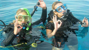 Girls in scuba diving gear giving ok signal