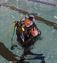 Eugene in scuba gear in pool, giving thumbs up